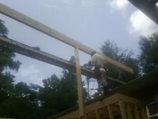 Carpenter setting a ridge beam over a new addition frame — Ice Dam Removal by Roofing Brothers in Montpelier Station