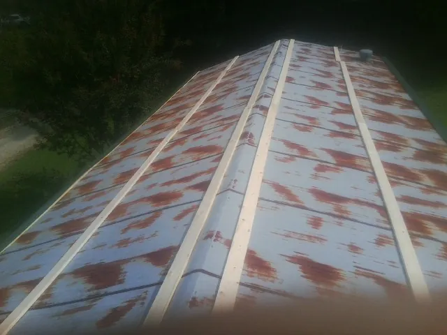 Rusted metal roof panels with new wood purlins before replacement — Storm Damage Roof Repair in Montpelier Station by Roofing Brothers