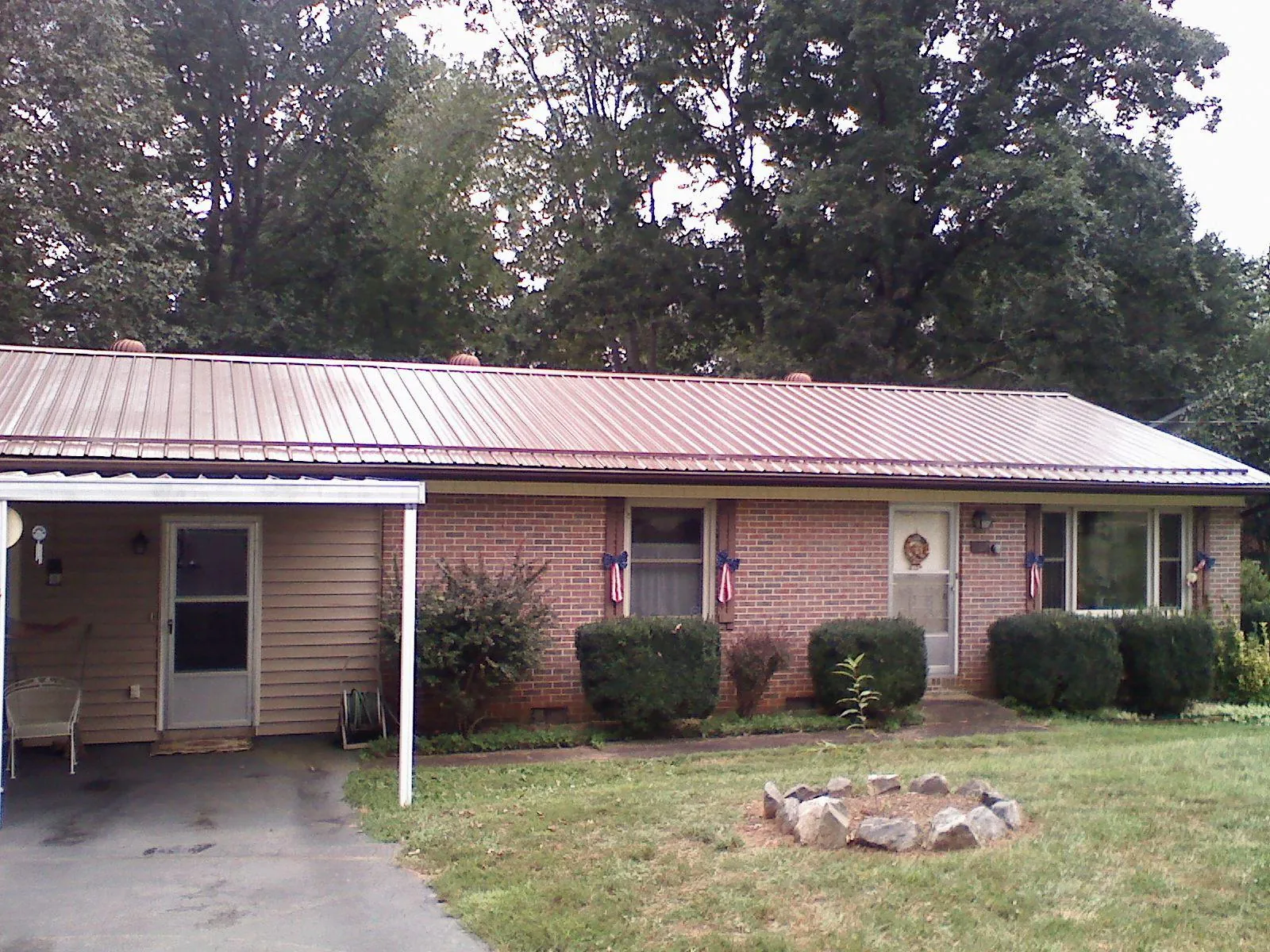 Bronze metal roof and carport on a brick ranch home — Roof Repair work by our crew in Montpelier Station